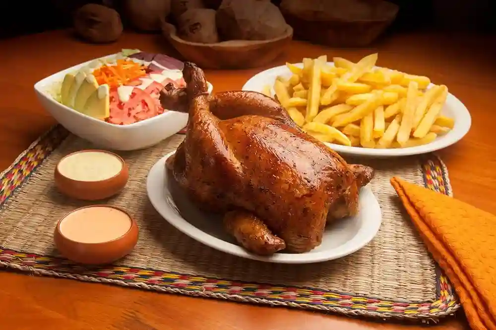 Pollo a la Brasa con acompañamiento de salsas papas fritas y ensalada